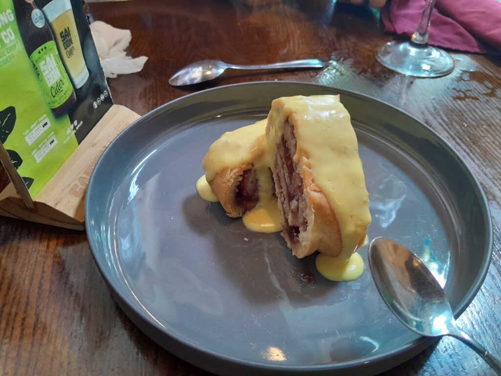 Jam roly-poly with a small amount of custard.