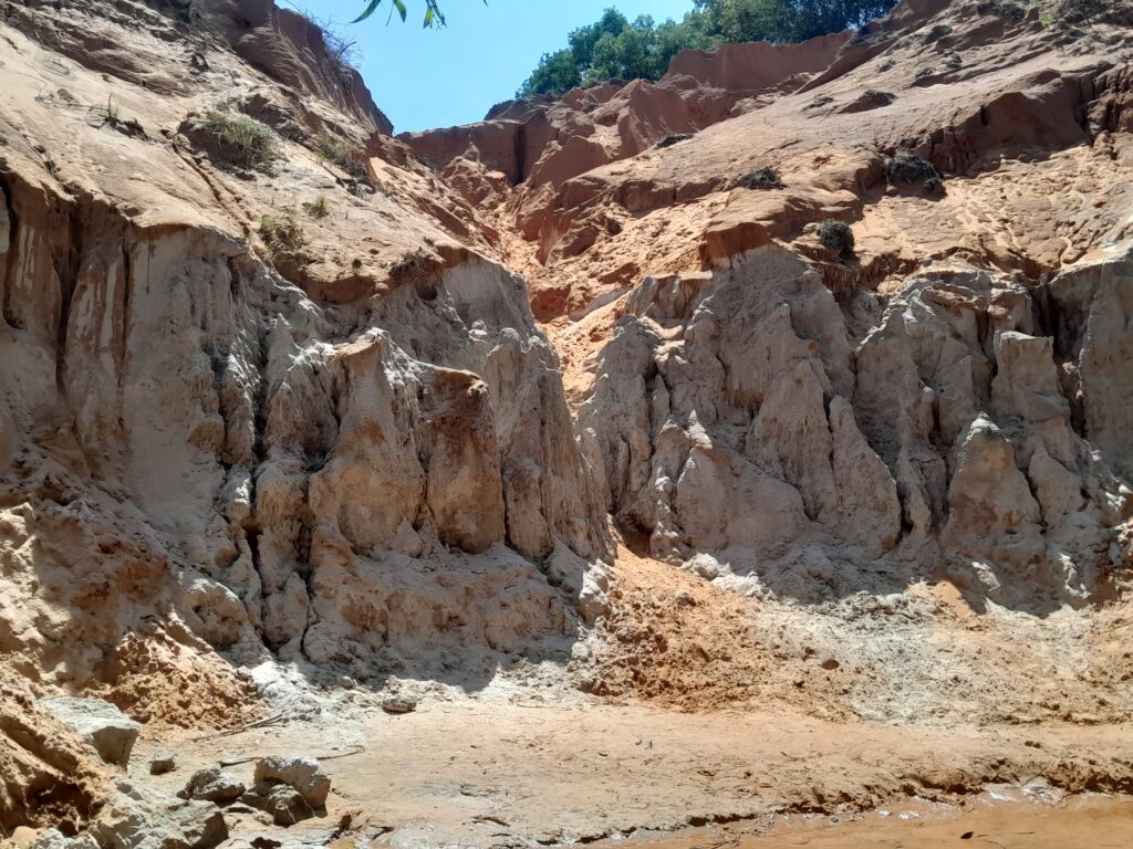 Limestone formations beneath the red clay of the small canyon.